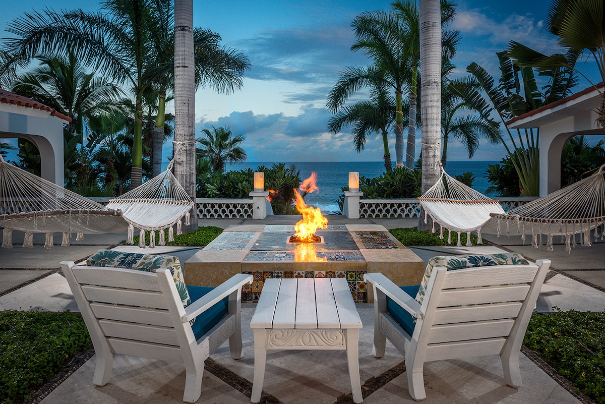 Gas fire table framed by hammocks and palms facing the Sea of Cortez at Casa Edwards, Palmilla