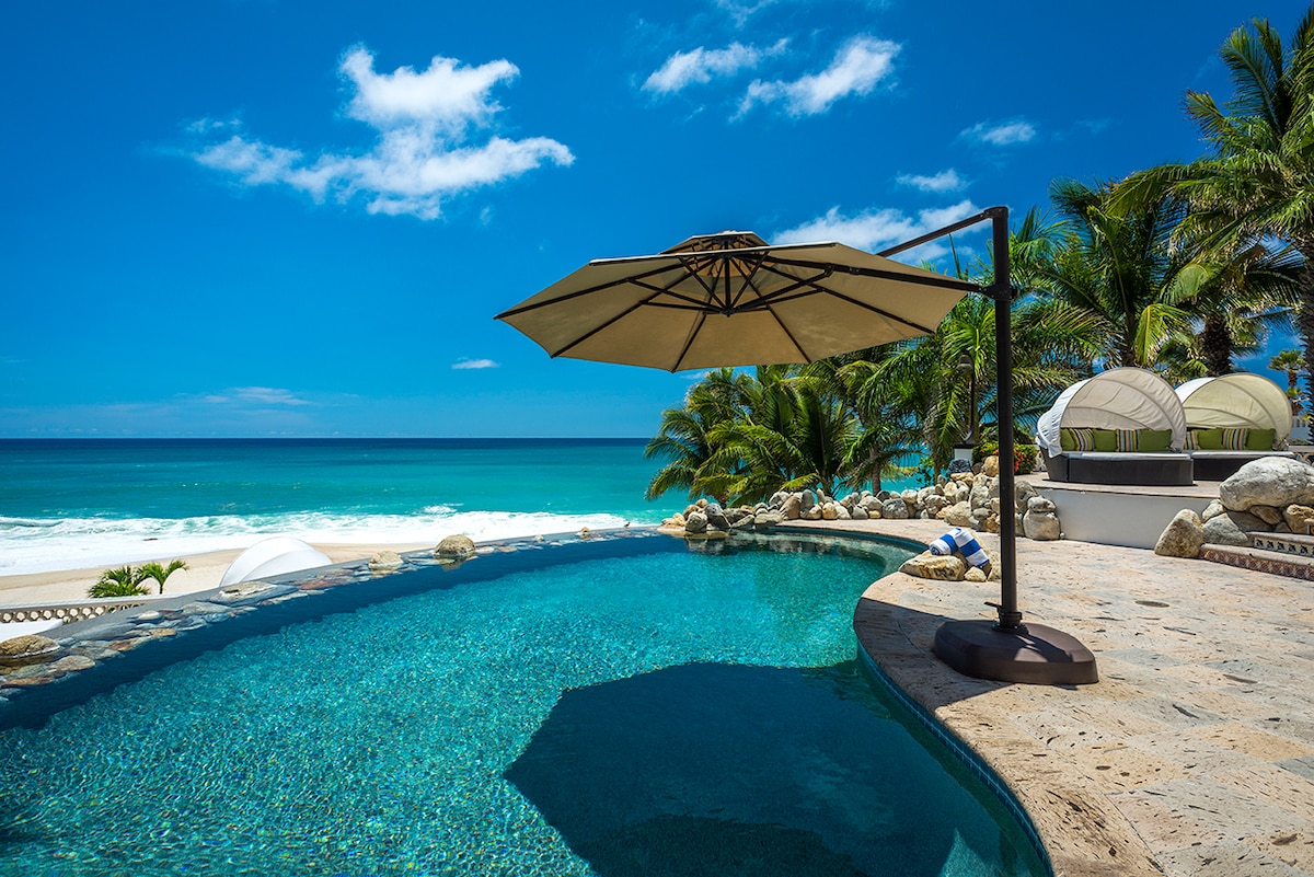 Infinity pool with shade umbrella facing the beach at Casa Edwards, Palmilla, Los Cabos