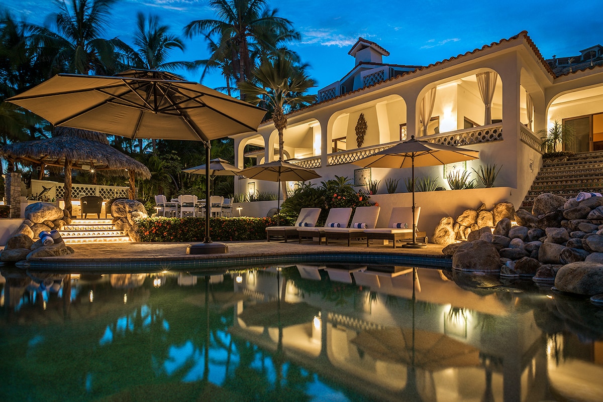 Swimming pool, terraces and lit facade at dusk at Casa Edwards, Palmilla, Los Cabos