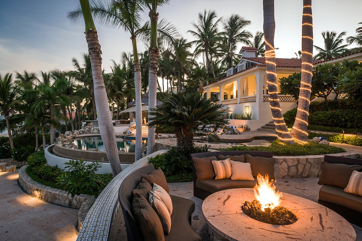 Gas fire pit lounge lit for the evening among the palms at Casa Edwards, Palmilla, Los Cabos