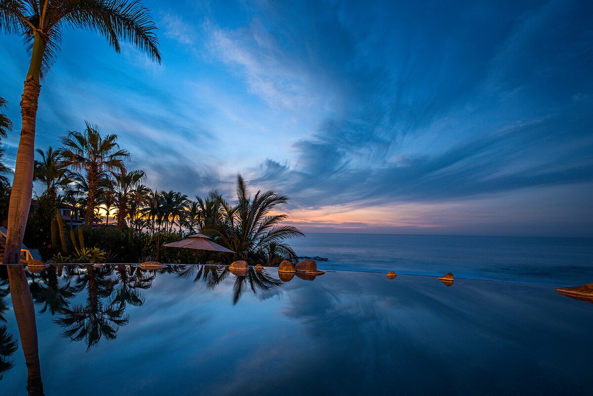 Infinity pool reflecting the palms and evening sky at Casa Edwards, Palmilla, Los Cabos