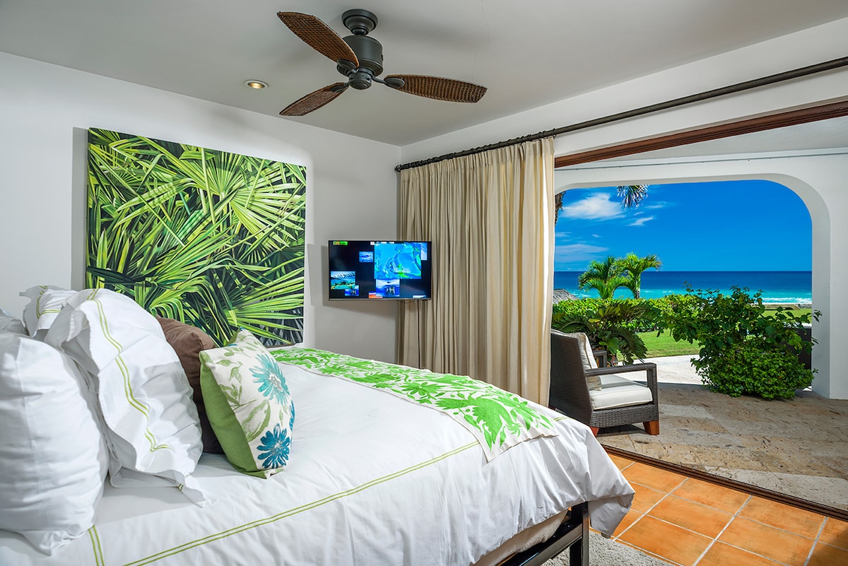 En-suite bedroom with tropical artwork, television and ocean view at Casa Edwards, Palmilla