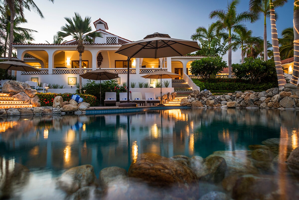 Swimming pool and villa lit at night at Casa Edwards, beachfront luxury villa in Palmilla