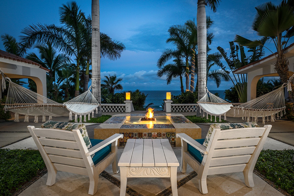 Evening view of the fire table lounge and hammocks above the beach at Casa Edwards, Palmilla