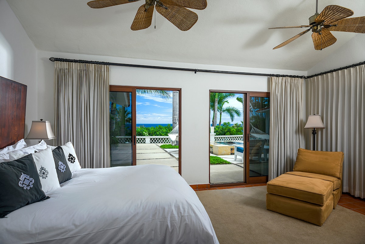 En-suite king bedroom with sitting area and doors to the terrace at Casa Edwards, beachfront villa in Palmilla
