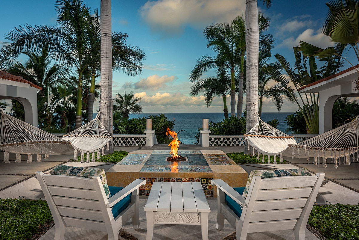 Gas fire table and hammocks lit at dusk facing the ocean at Casa Edwards, Palmilla, Los Cabos